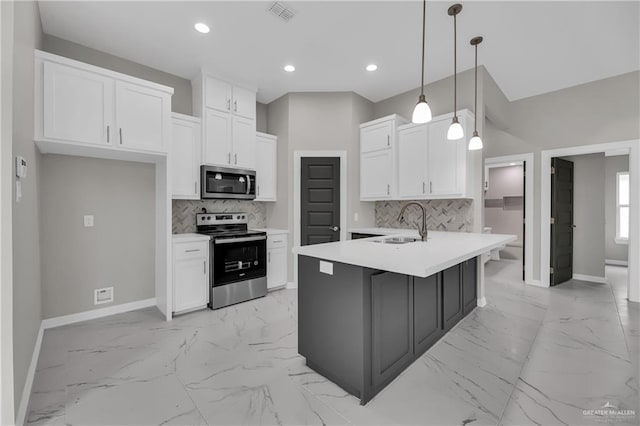 kitchen featuring a kitchen island with sink, hanging light fixtures, white cabinets, and stainless steel appliances