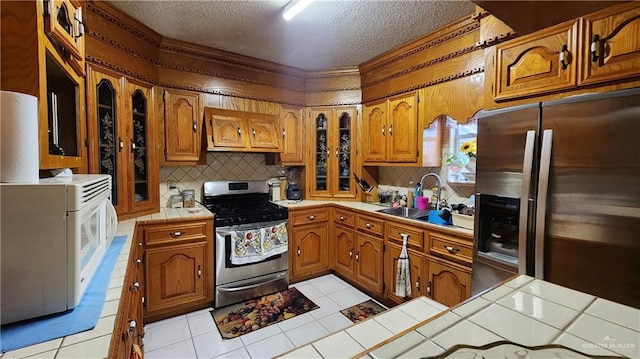 kitchen with sink, tile counters, and appliances with stainless steel finishes