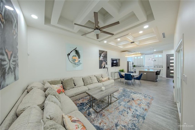 living room featuring light wood-type flooring, beam ceiling, a ceiling fan, coffered ceiling, and recessed lighting