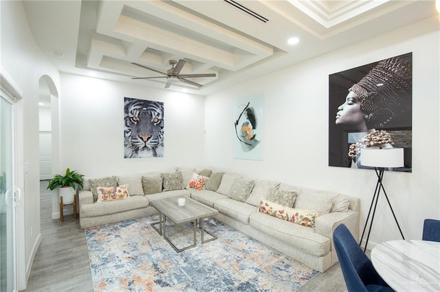 living room with a ceiling fan, coffered ceiling, wood finished floors, recessed lighting, and arched walkways