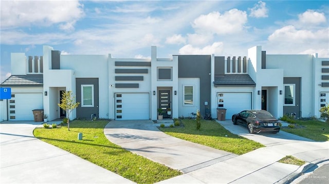 view of front facade with stucco siding, a front lawn, a garage, and driveway