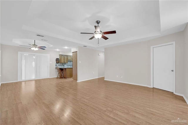 517 Gemini St, Mission, TX 78572 - unfurnished living room with a raised ceiling, ceiling fan, light wood finished floors, and baseboards