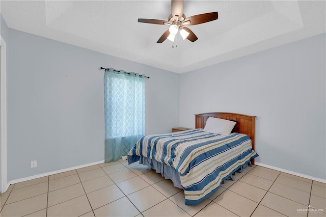 517 Gemini St, Mission, TX 78572 - bedroom with tile patterned flooring, ceiling fan, baseboards, and a tray ceiling
