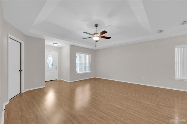 517 Gemini St, Mission, TX 78572 - unfurnished living room with a raised ceiling, a ceiling fan, light wood-type flooring, and baseboards