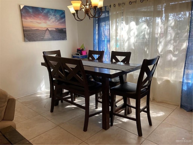 dining space with tile patterned flooring and a notable chandelier