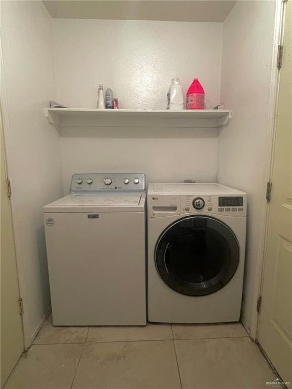 laundry room with light tile patterned flooring, independent washer and dryer, and laundry area