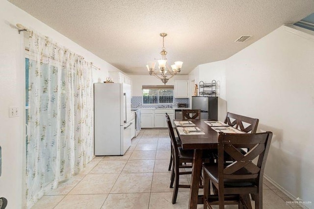 3301 Princeton Ave, Mcallen, TX 78504 - dining area featuring a chandelier, a textured ceiling, and light tile patterned flooring