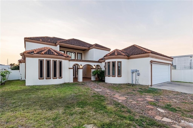 3909 S M St, Mcallen, TX 78503 - back of property at dusk featuring a garage, driveway, a tiled roof, and stucco siding