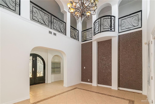 3909 S M St, Mcallen, TX 78503 - foyer entrance with a towering ceiling, arched walkways, a chandelier, tile patterned flooring, and inlaid floor details