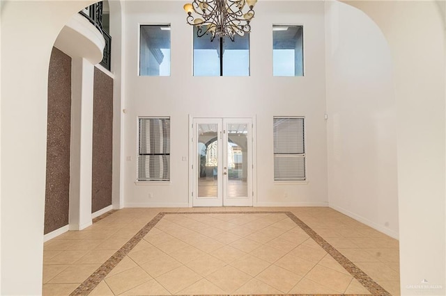 3909 S M St, Mcallen, TX 78503 - spare room with inlaid floor details, a chandelier, arched walkways, a high ceiling, and french doors