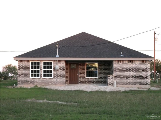 12517 Mile 2 W, Weslaco, TX 78599 - view of front of property featuring brick siding, roof with shingles, and a front lawn