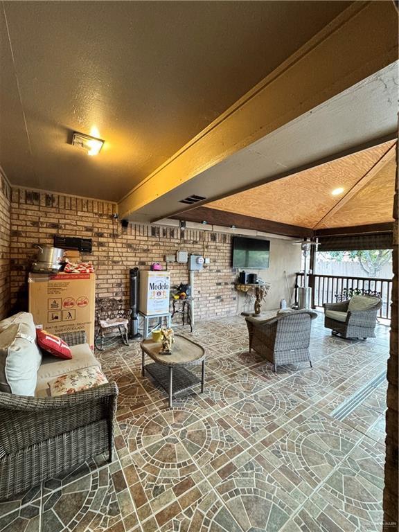 704 S 17th St, Hidalgo, TX 78557 - living room with brick wall and beam ceiling