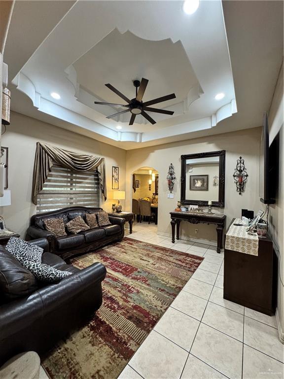704 S 17th St, Hidalgo, TX 78557 - living area with a raised ceiling, arched walkways, light tile patterned floors, a ceiling fan, and recessed lighting