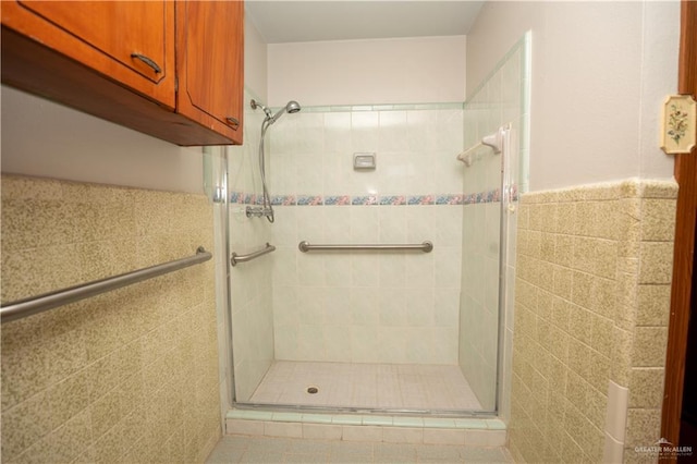 bathroom featuring a shower with door and tile walls