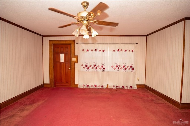 empty room featuring a textured ceiling, ceiling fan, dark carpet, and crown molding