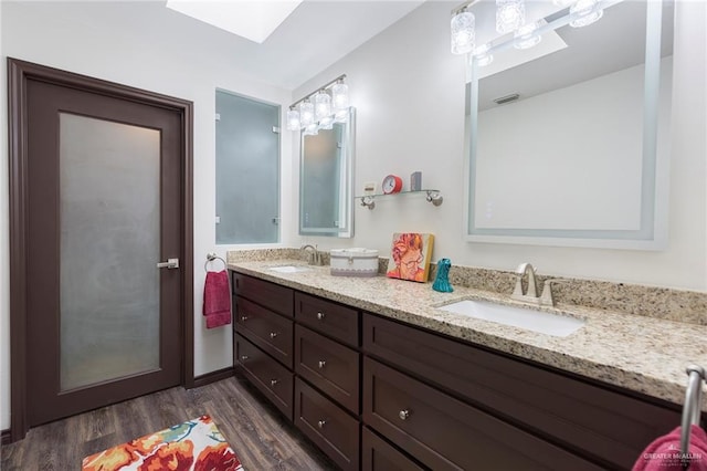 bathroom featuring hardwood / wood-style floors, vanity, and a skylight