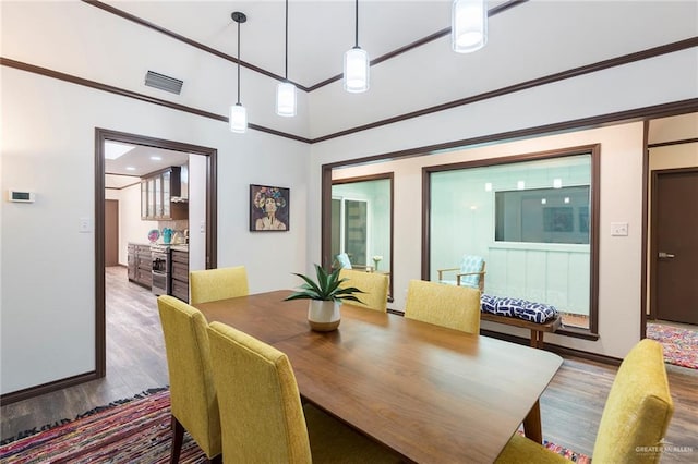 dining room featuring a towering ceiling and hardwood / wood-style flooring