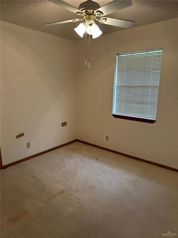 carpeted empty room with ceiling fan and a textured ceiling