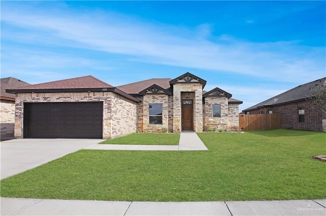 french country style house featuring a garage and a front lawn