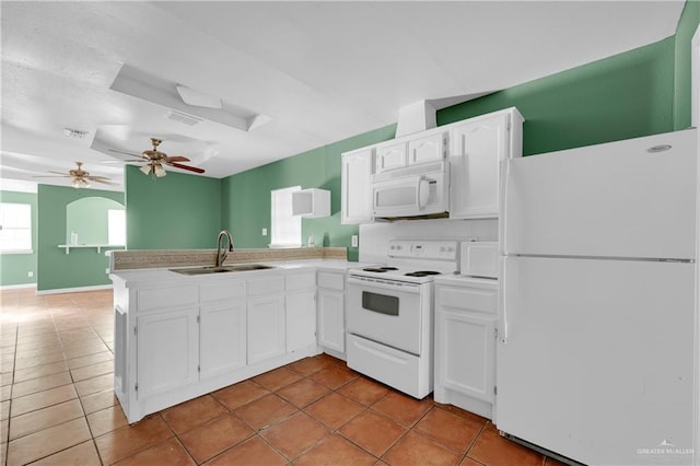 kitchen featuring white appliances, white cabinets, a sink, and a peninsula