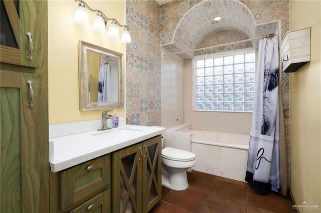 full bathroom featuring tile patterned floors, shower / bath combination with curtain, toilet, vanity, and tile walls