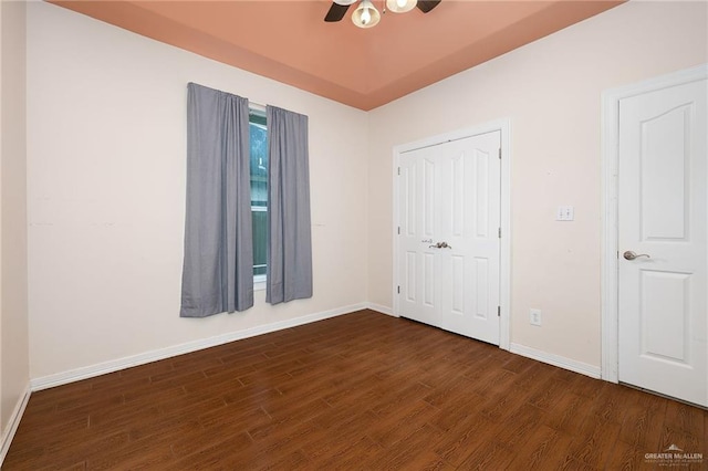 unfurnished bedroom with ceiling fan, dark hardwood / wood-style flooring, and a closet