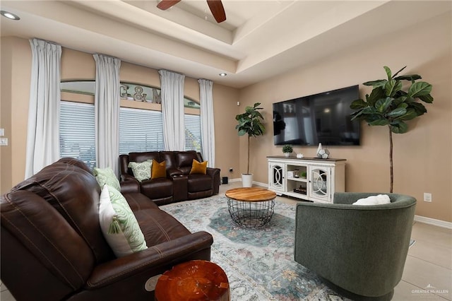 tiled living room featuring a raised ceiling and ceiling fan