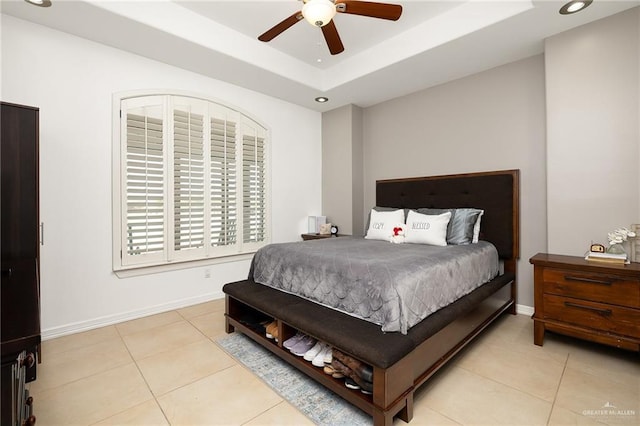 tiled bedroom featuring a raised ceiling and ceiling fan