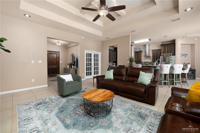 living room featuring light tile patterned floors, a raised ceiling, ceiling fan, and french doors