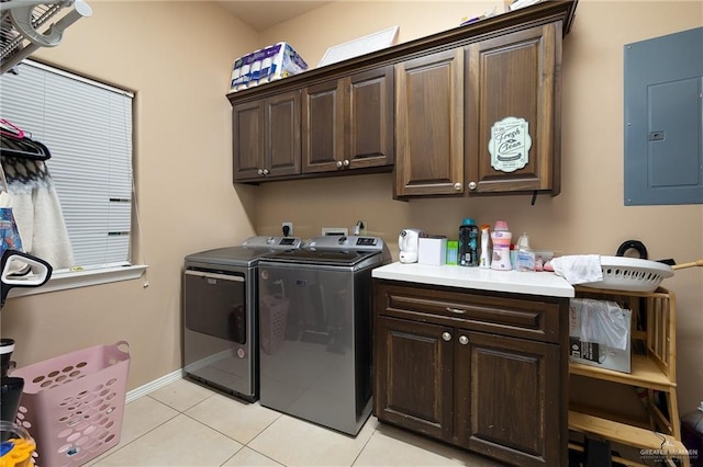 laundry room with washer and dryer, electric panel, cabinets, and light tile patterned flooring