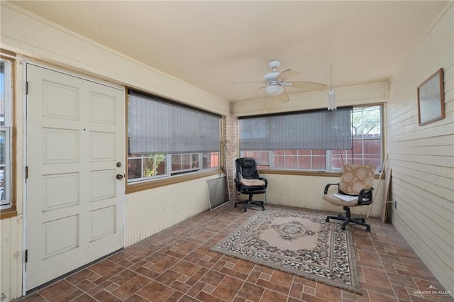 unfurnished sunroom with ceiling fan