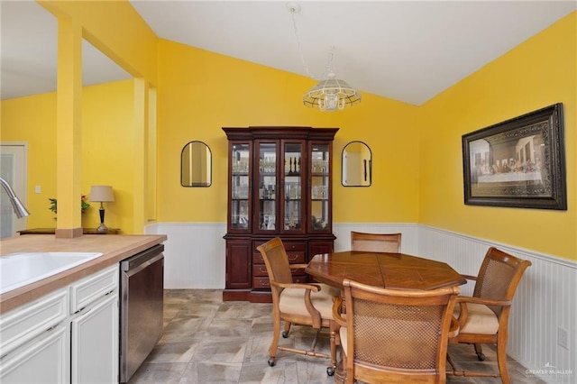 dining space with sink and vaulted ceiling