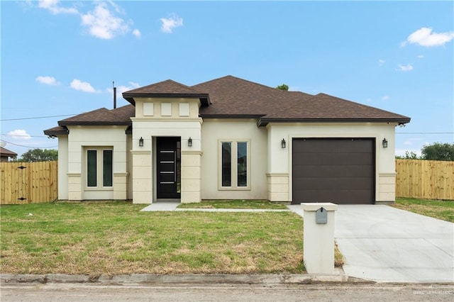 prairie-style home featuring a garage and a front lawn