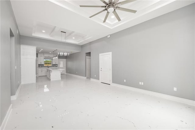 unfurnished living room with a tray ceiling and ceiling fan