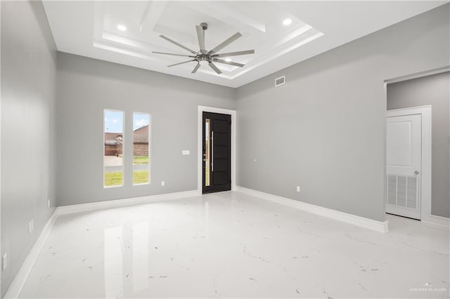 empty room featuring coffered ceiling, ceiling fan, and a high ceiling