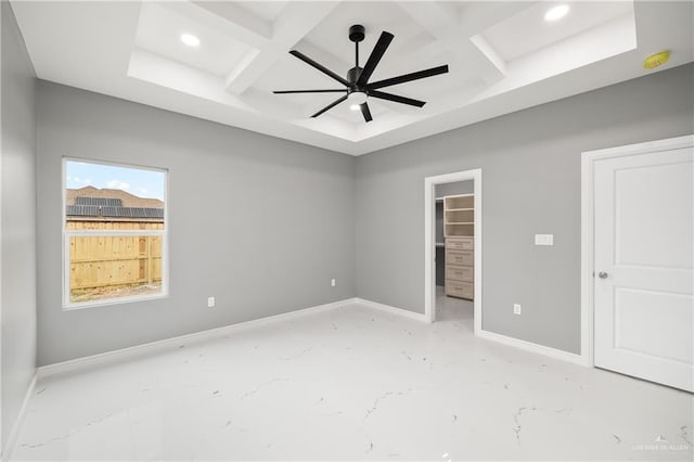 unfurnished bedroom with a closet, coffered ceiling, beam ceiling, and a spacious closet