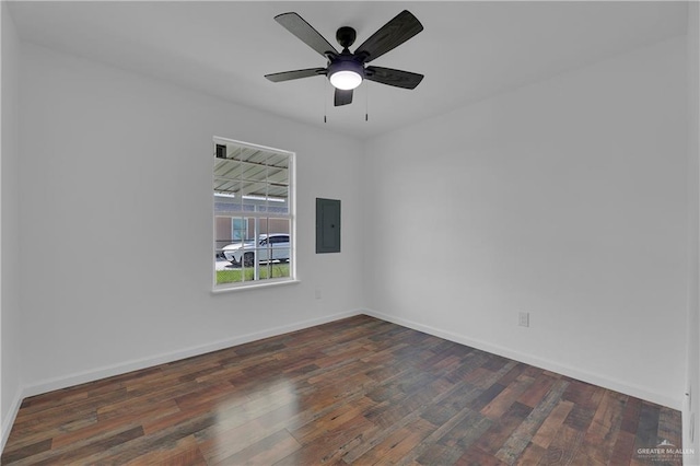 empty room with dark hardwood / wood-style flooring, electric panel, and ceiling fan