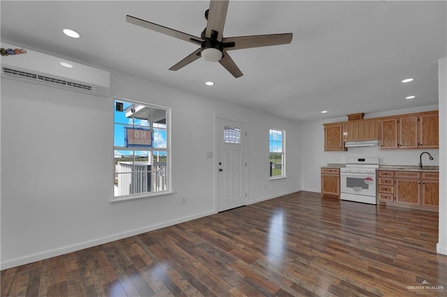 kitchen featuring ceiling fan, sink, dark hardwood / wood-style floors, white range oven, and a wall mounted AC