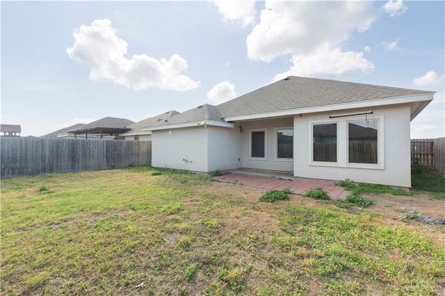 rear view of house with a yard and a patio area