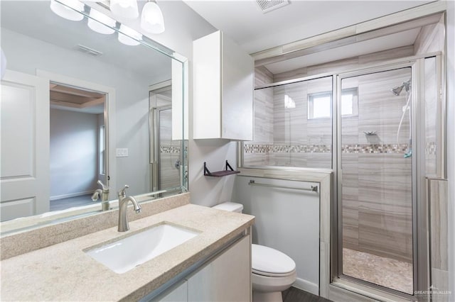 bathroom featuring vanity, an enclosed shower, and toilet