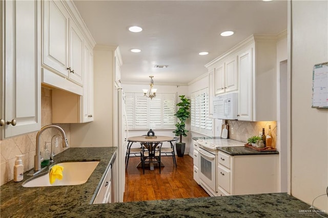 kitchen with visible vents, dark wood-type flooring, white cabinets, a sink, and white appliances