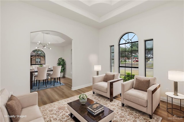 living room featuring light hardwood / wood-style floors, plenty of natural light, and a notable chandelier