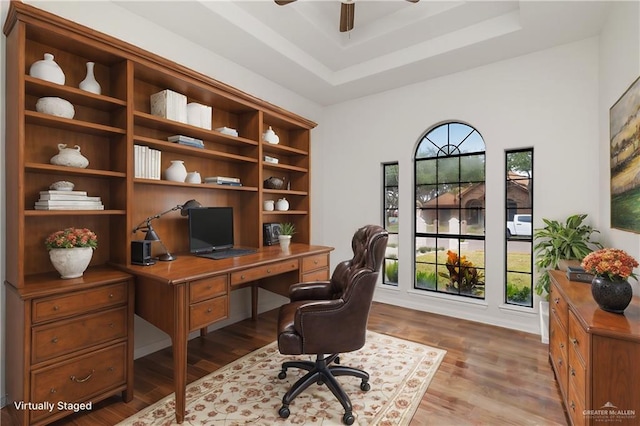 office area with a raised ceiling and wood-type flooring