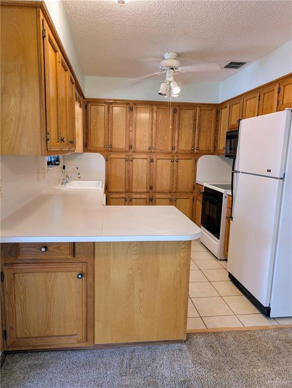 109 Green Gate Cir N, Palmview, TX 78572 - kitchen featuring white appliances, a peninsula, brown cabinets, ceiling fan, and light countertops