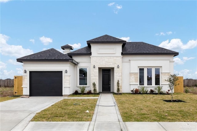 view of front facade with stucco siding, concrete driveway, fence, a garage, and a front lawn