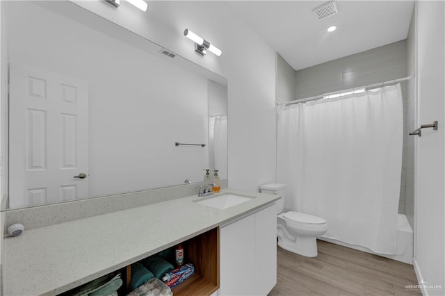 full bathroom featuring vanity, wood-type flooring, shower / tub combo with curtain, and toilet