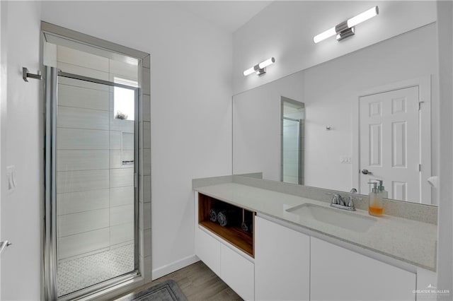 bathroom featuring a shower with door, vanity, and hardwood / wood-style flooring