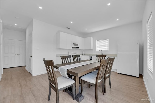 dining room with sink and light hardwood / wood-style flooring