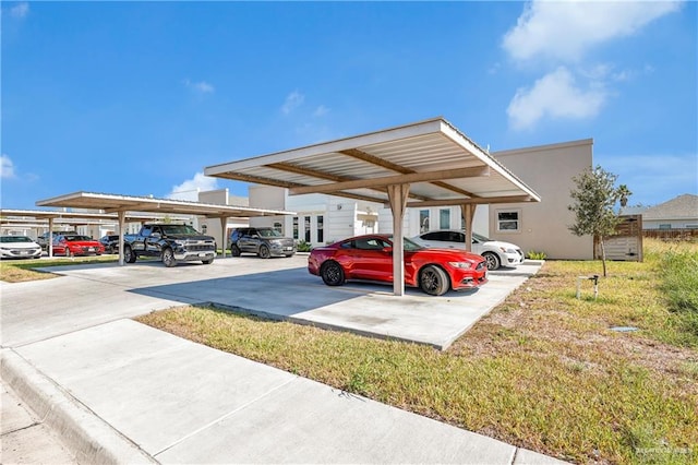 view of parking / parking lot with a carport and a yard