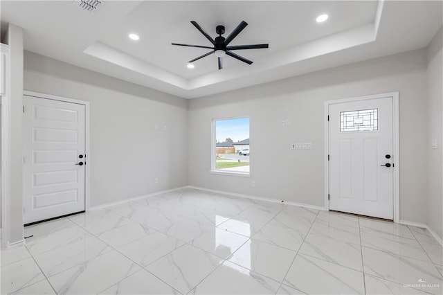 entryway with a tray ceiling and ceiling fan